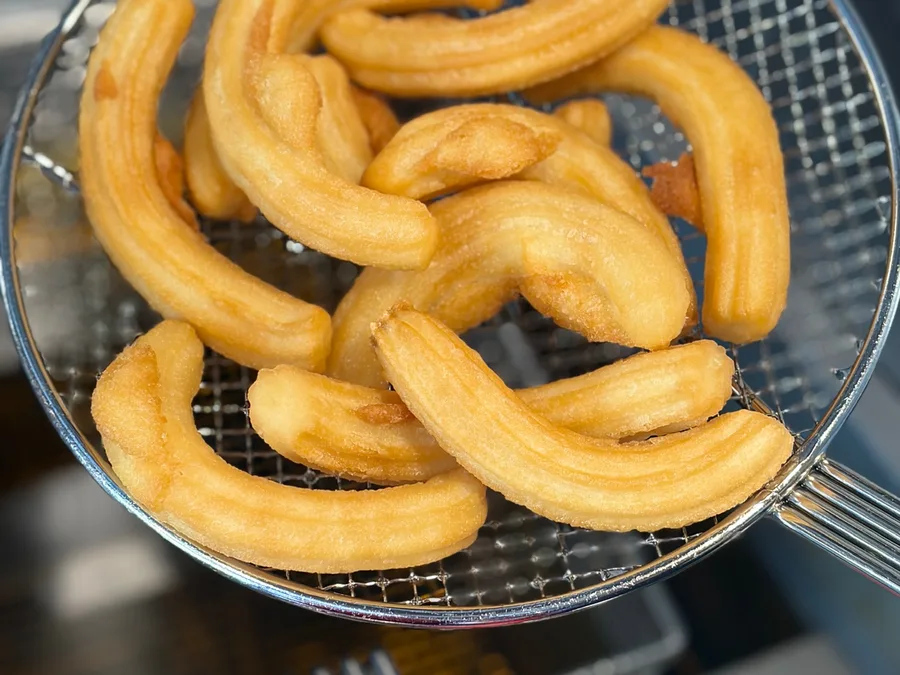 Churros frying fresh in the basket